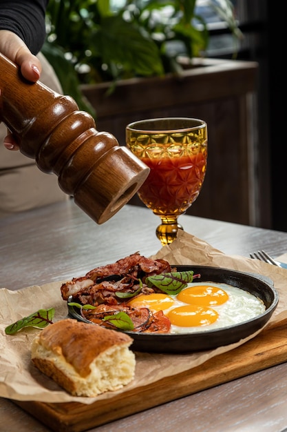 Breakfast of eggs and bacon, served with fresh pastries and tomato juice