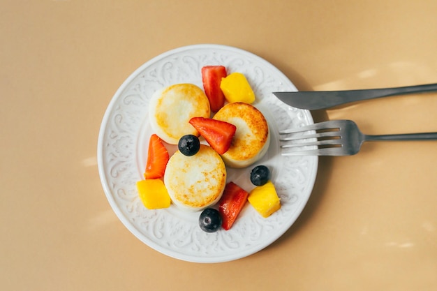 Breakfast food concept Cottage cheese pancakes on plate Syrniki with berry top view