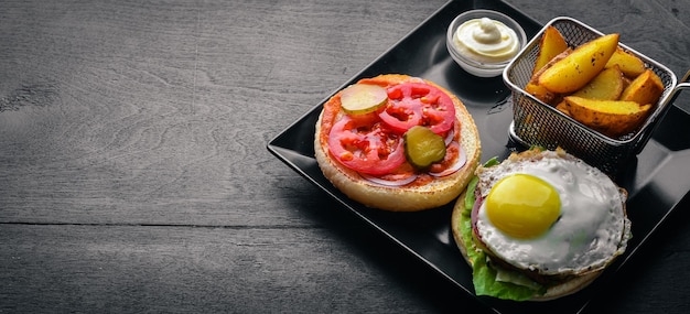 Breakfast French fries and burger with meat and egg On a wooden background Top view Free space