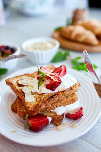 Breakfast of french toast with strawberries and maple syrup