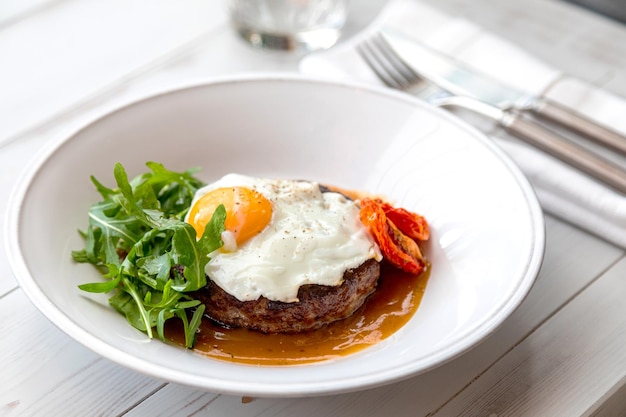 Breakfast fried eggs with beefsteak arugula and sundried tomato