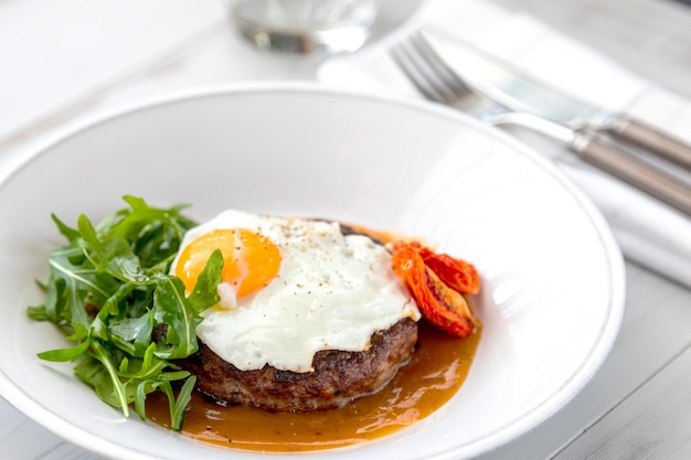 Breakfast fried eggs with beefsteak arugula and sundried tomato