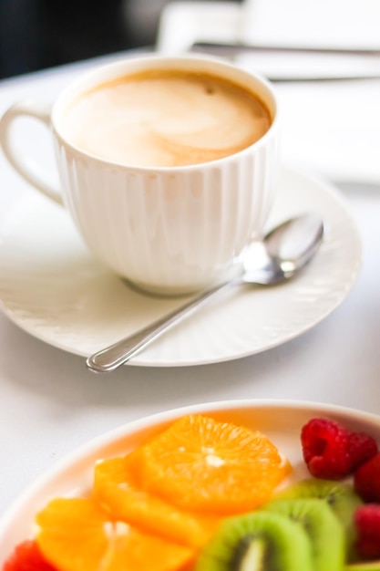 Breakfast and luxury cup of coffee with milk and fruit platter on the served table for hospitality and gastronomy