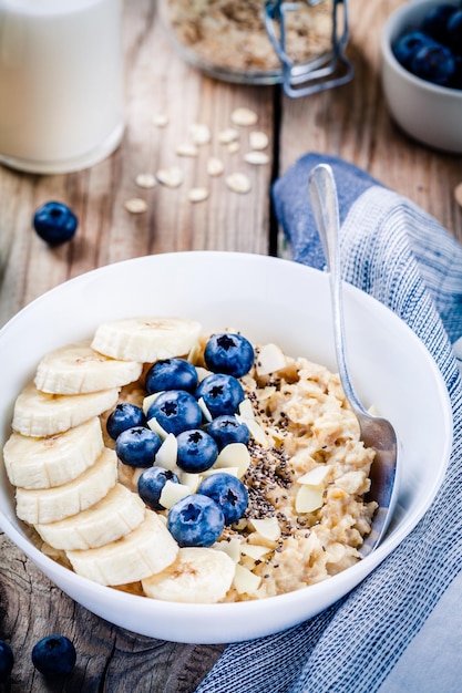 Breakfast oatmeal with bananas blueberries chia seeds and almonds Selective focus