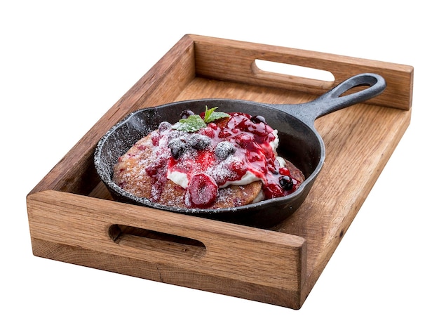 Breakfast in a pan on a white background Pancakes with cream and jam On a wooden tray