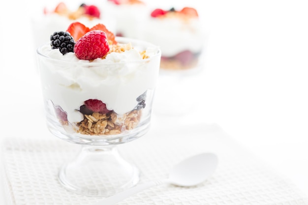 Breakfast parfait made from Greek yogurt and granola topped with fresh berries.