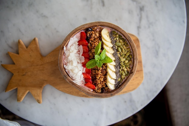 Breakfast smoothie bowl topped granola strawberry coconut nuts sunflower banana and chia seeds