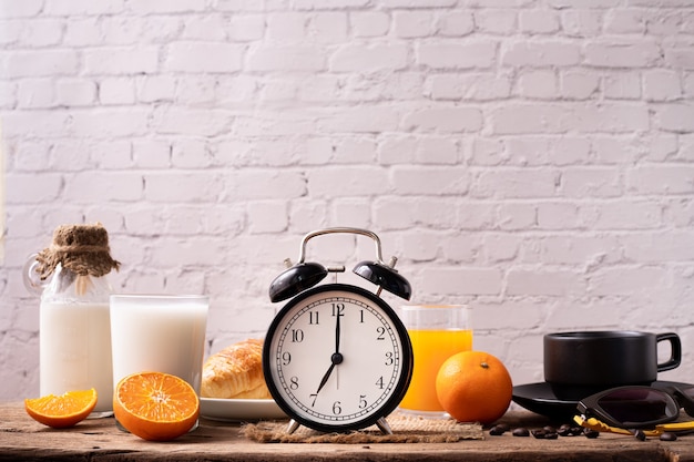 Breakfast table with classic alarm clock and breakfast.