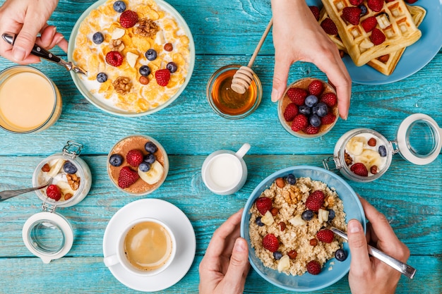 Breakfast table with waffles, oatmeal, cereals, coffee, juice and fresh berries