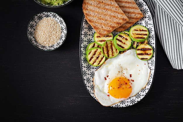 Breakfast Toast with avocado guacamole grilled zucchini and fried egg Brunch Top view flat lay