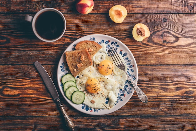 Breakfast toast with fried eggs with vegetables fruits and coff