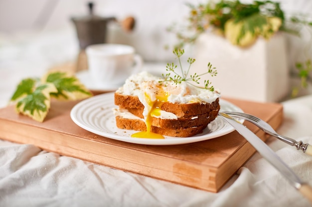 Breakfast on white bed sheets good morning toast with poached eggs coffee