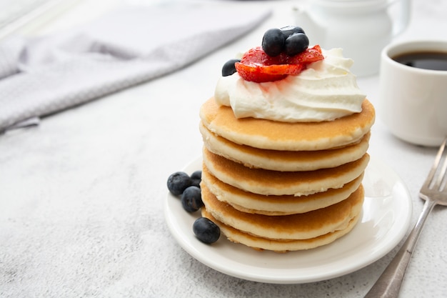 Breakfast wih Pancakes, cream, berry and coffee cup isolated on white 