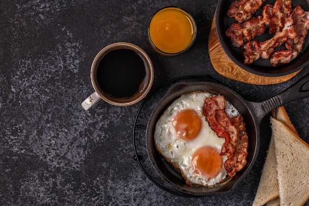 Breakfast with bacon , fried egg, coffee and orange juice