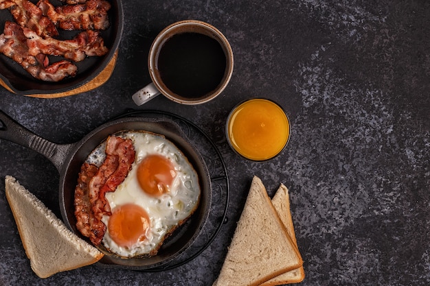 Breakfast with bacon , fried egg, coffee and orange juice