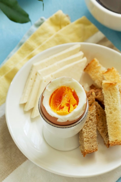 Breakfast with boiled eggs, cheese, bread toast and coffee. Rustic style.