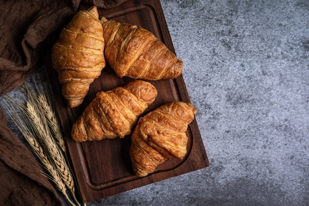 Breakfast with fresh croissants on wooden board