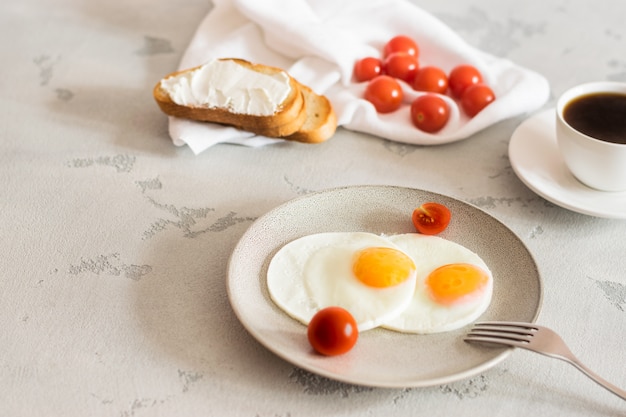 Breakfast with fried eggs, tomatoes, toast and invigorating coffee