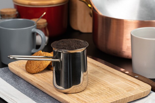 Brewed coffee in a metal turk on a kitchen counter close up