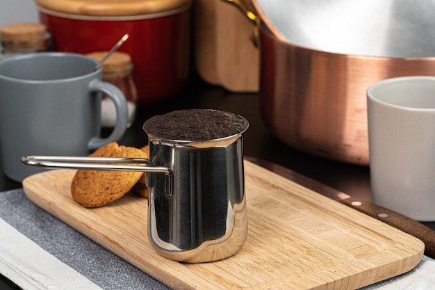 Brewed coffee in a metal turk on a kitchen counter close up