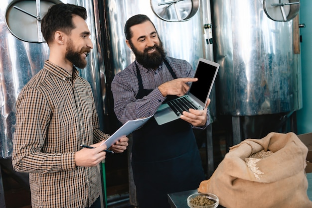 Brewer Man Points to Laptop Screen Microbrewery