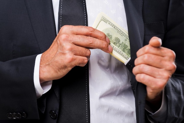 Bribe. Close-up of businessmen hiding money to his pocket