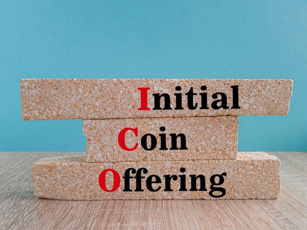 Brick blocks with words ICO initial coin offering Beautiful blue background wooden table