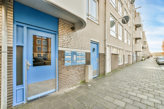 A brick building with blue doors and a brick sidewalk