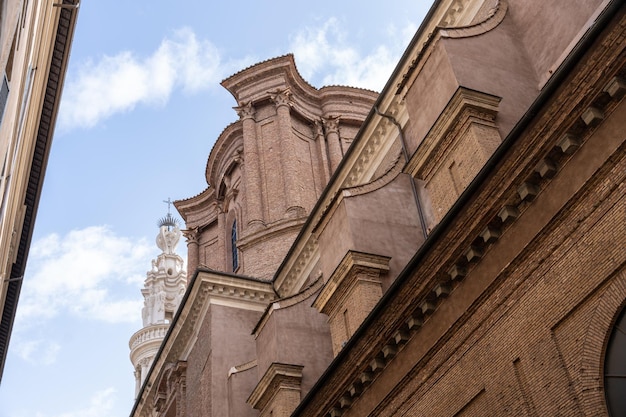 A brick building with a tall tower and a statue on top