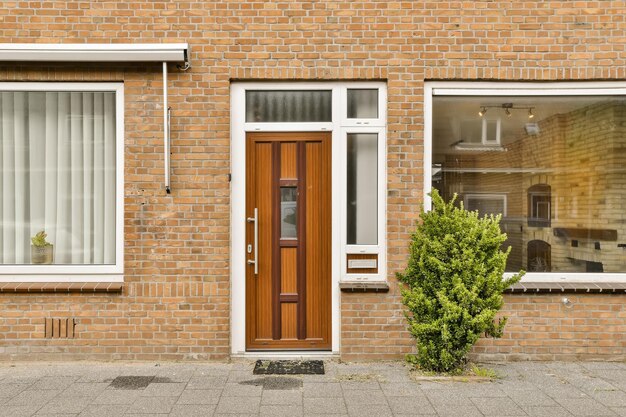 Photo a brick building with two windows and a small tree in the foreground is on the left side of the photo