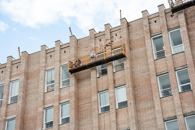 A brick building with a yellow scaffolding on the side of it.