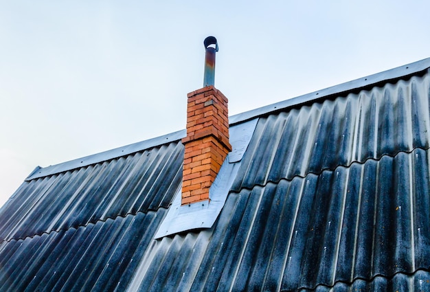 A brick chimney on the roof of an old house.