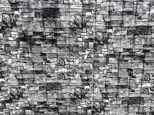 A brick gray wall of small tiles of different shapes and shades on the whole background