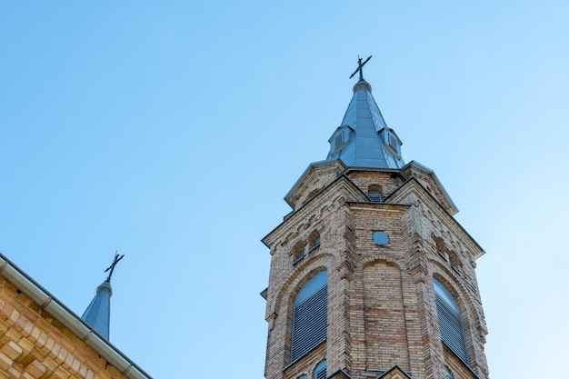 Brick tower of a Church or Church against the blue sky old building in the Gothic style