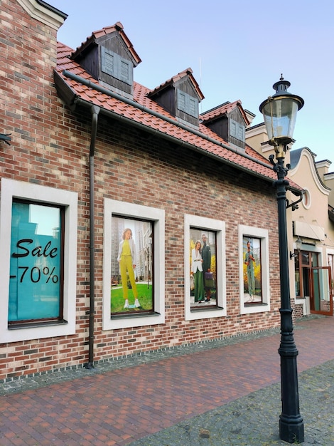 In the brick wall of a clothing store,there are three decorative showcases with photographs of human