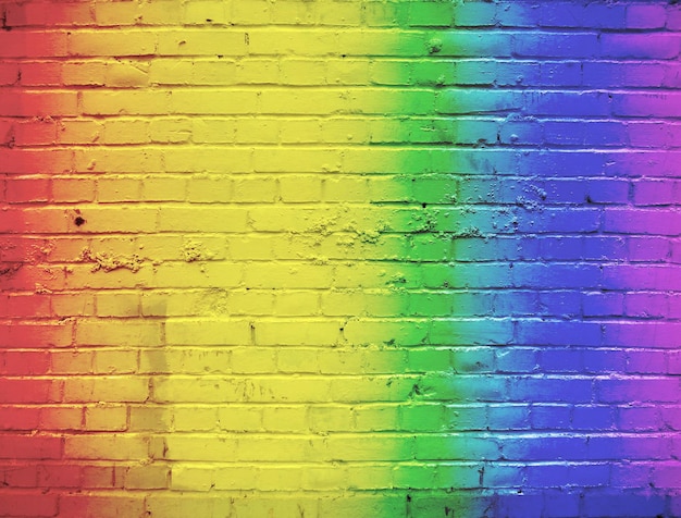 A brick wall painted in a rainbow color