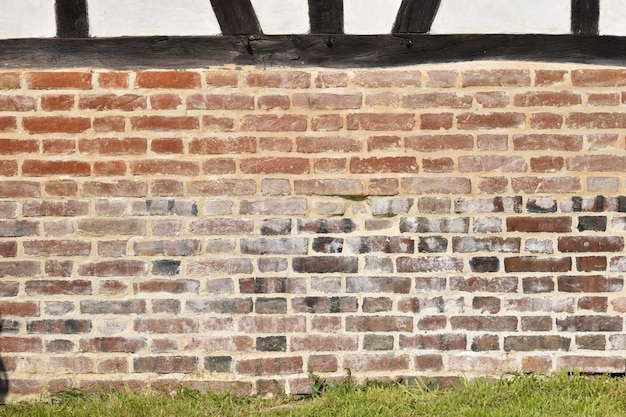 Photo a brick wall with grass and wood