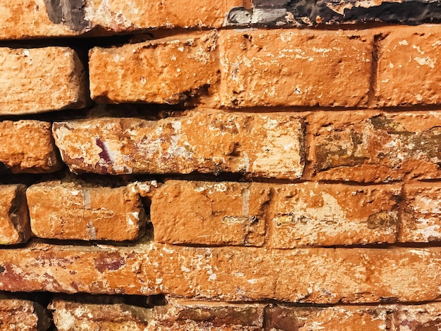 A brick wall with a lot of cracks and holes