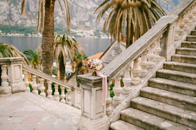 Bridal bouquet on the railing of an ancient staircase