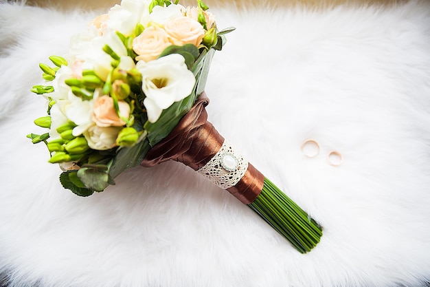 Bridal bouquet and rings on white background