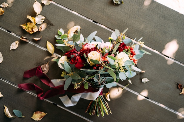 Bridal bouquet of white and red roses peonies branches of eucalypt tree alstroemeria and