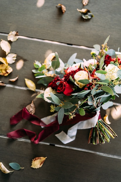 Bridal bouquet of white and red roses peonies branches of eucalypt tree alstroemeria and