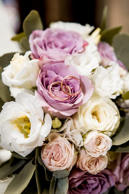 Bridal bouquet with purple and white flowers and rings