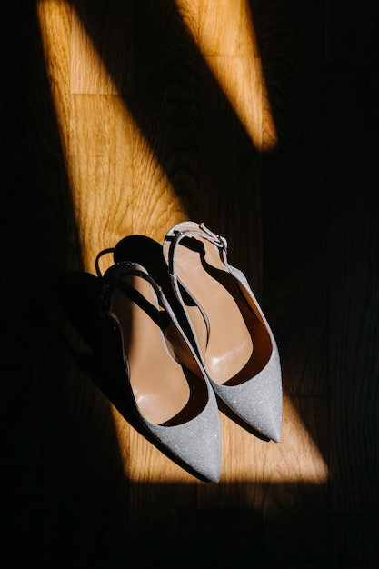 Bridal silver shoes on wooden floor