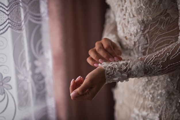 The bride adjusts the lace sleeves of the dress 4263