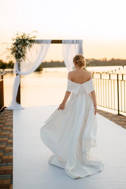 Bride against the background of a yellow sunset