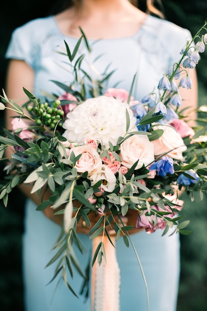 Bride in blue dress holding wedding bouquet