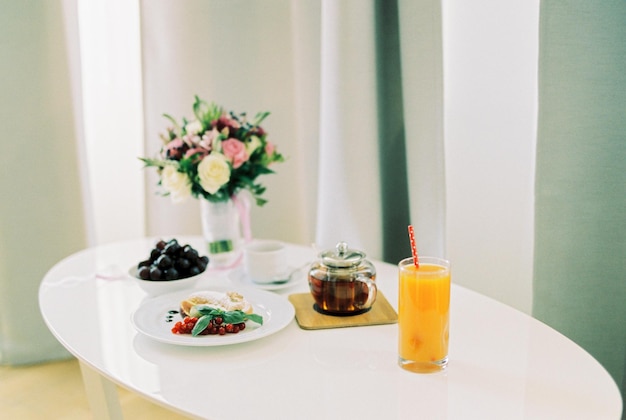 Bride breakfast on a white table next to a bouquet of flowers