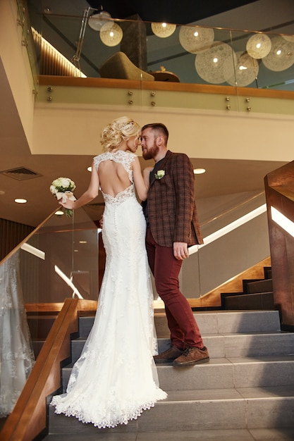 Bride in a chic long dress with a train and groom