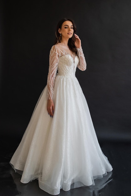 Bride at the clothes shop for wedding dresses she is choosing a dress and the designer is assisting